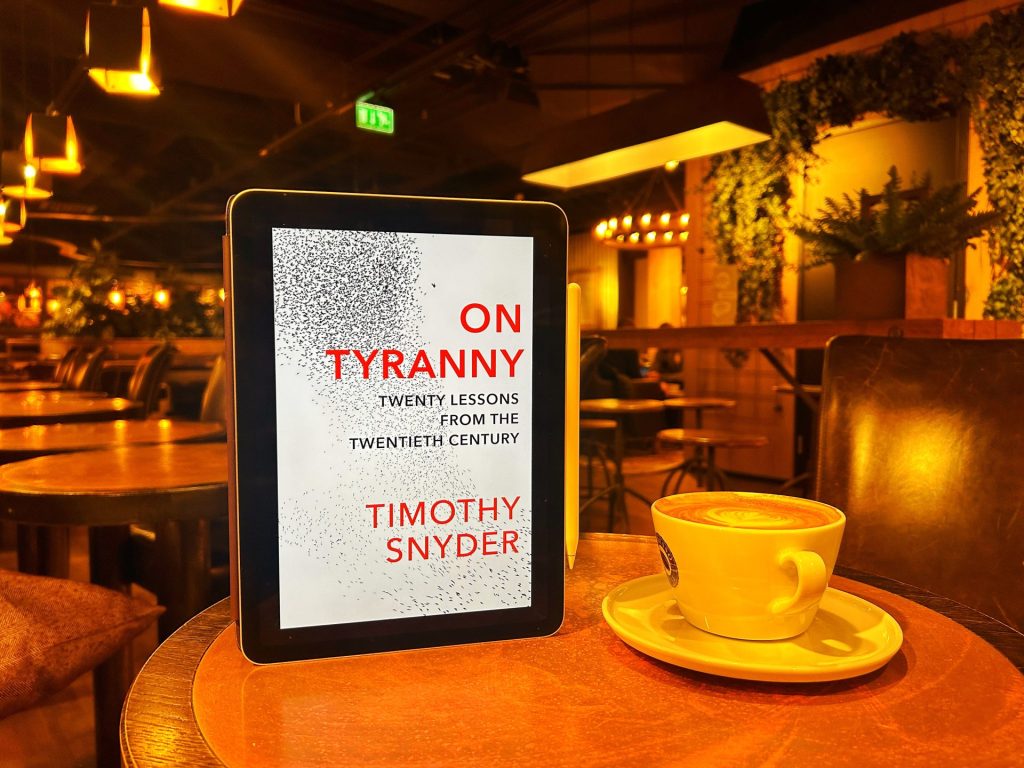 On Tyranny eBook with a cup of coffee on a table.