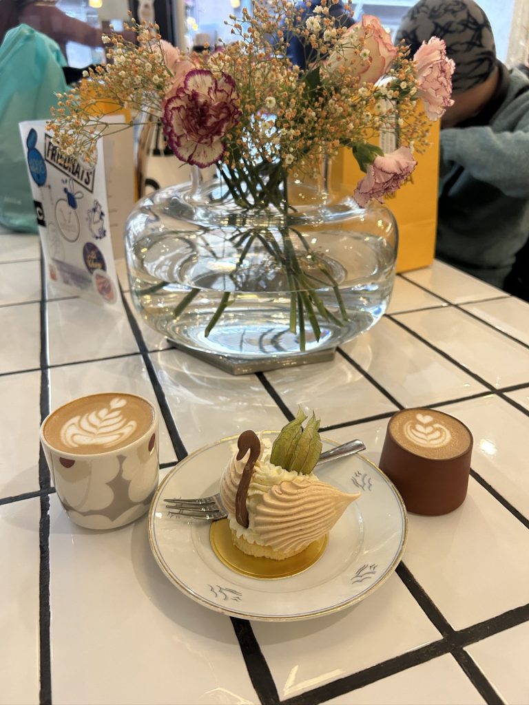 Yuzu Swan with a cup of cappucino and a cortado