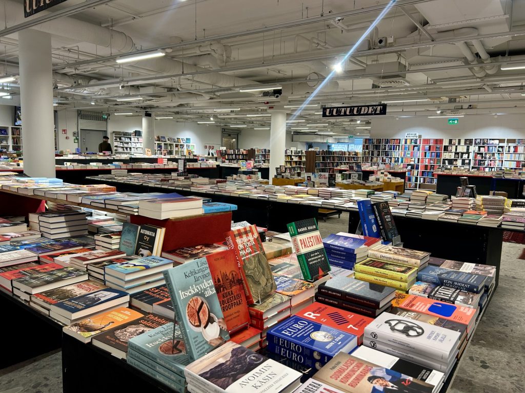 Inside Rosebud Sivullinen bookstore showing roomy aisles and shelves filled with books across many genres
