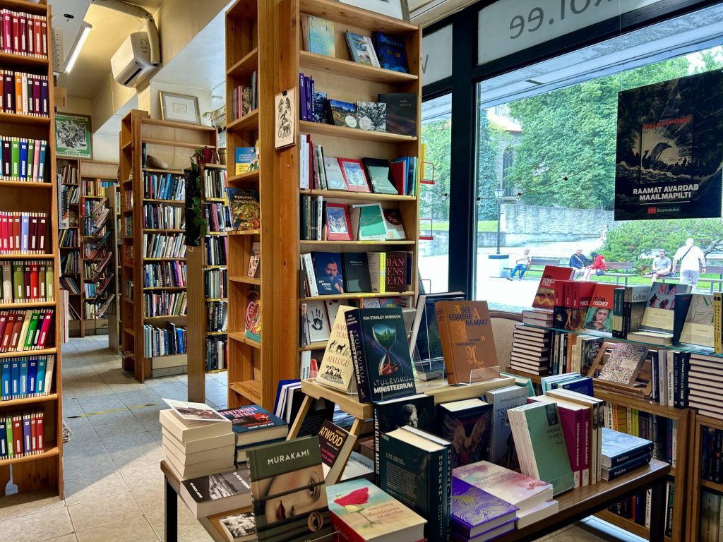 Multiple wooden bookshelves inside a secondhand bookstore.