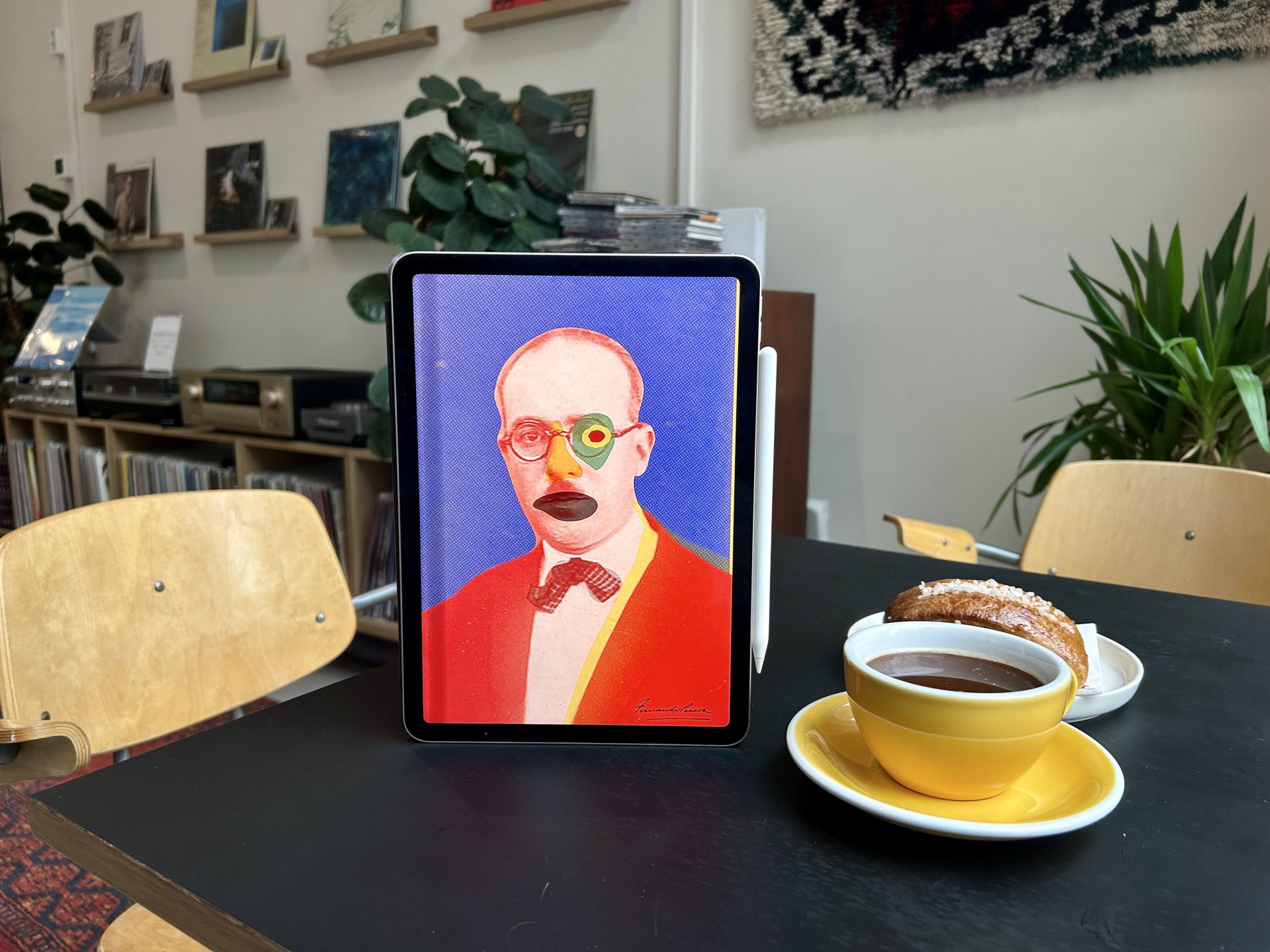 The Book of Disquiet eBook on a dark table with a cup of coffee