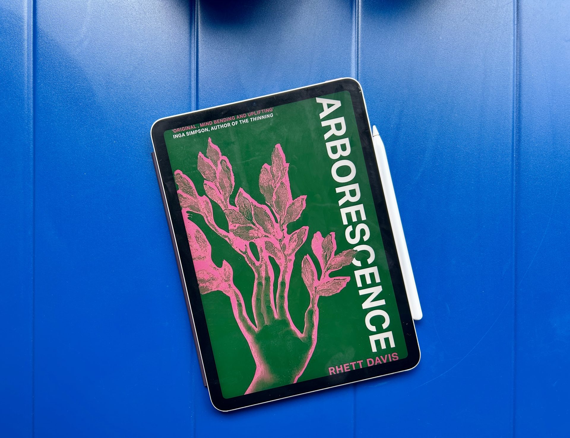 Arborescence eBook on a solid blue table